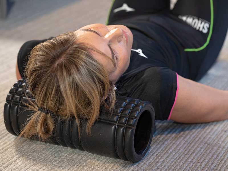Donna utilizza un foam roller sotto la zona cervicale