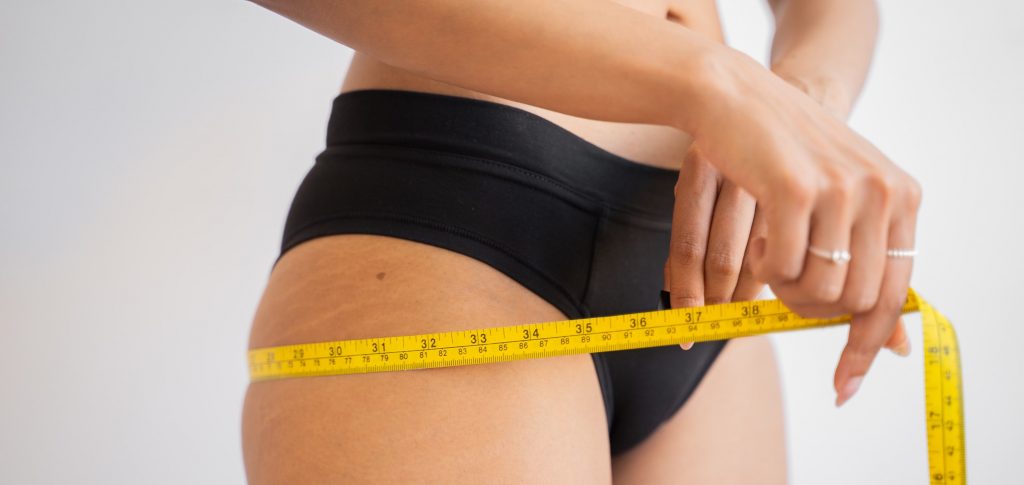 donna obesa si misura la circonferenza delle sue cosce 
