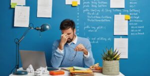 uomo stressato si tiene la testa