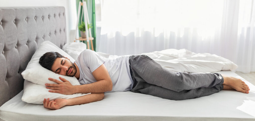 ragazzo previene il torcicollo dormendo con un cuscino e materasso ortopedici