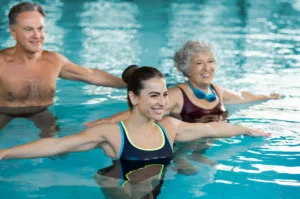 uomo e donna anziani si allenano in piscina con personal trainer