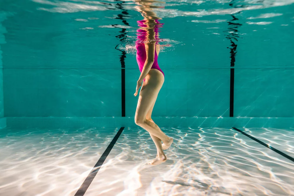 donna in piedi in acqua si prepara a fare esercizi per la schiena