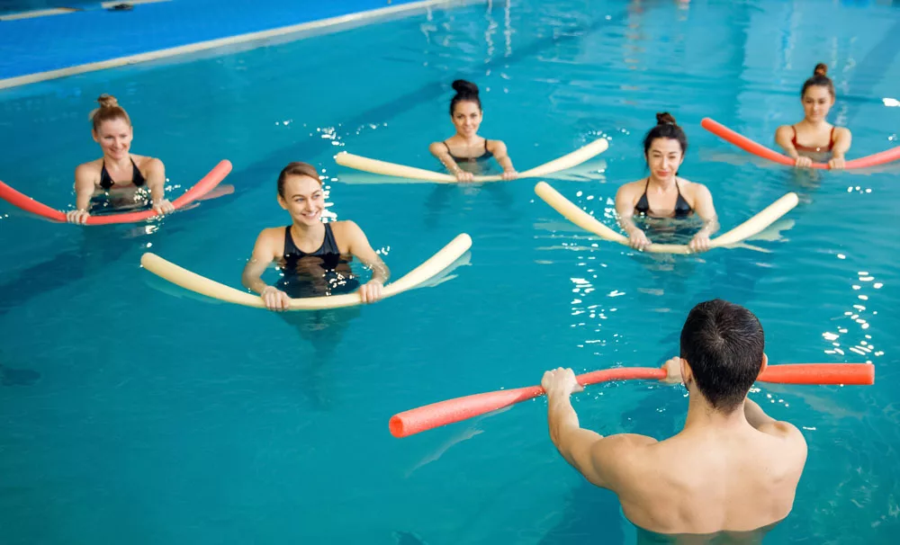 gruppo di donne fanno con galleggiante esercizi in piscina per la schiena 
