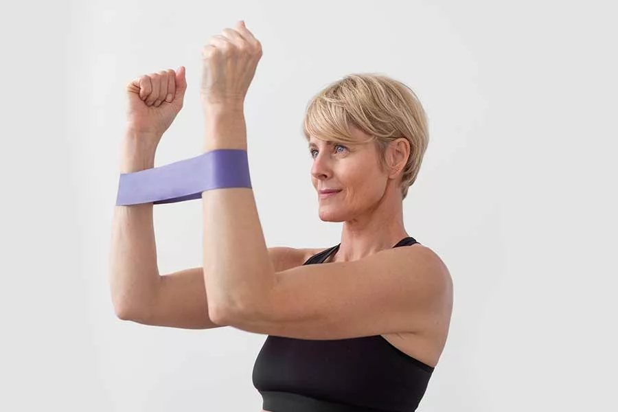 donna fa un allenamento braccia utilizzando un elastico