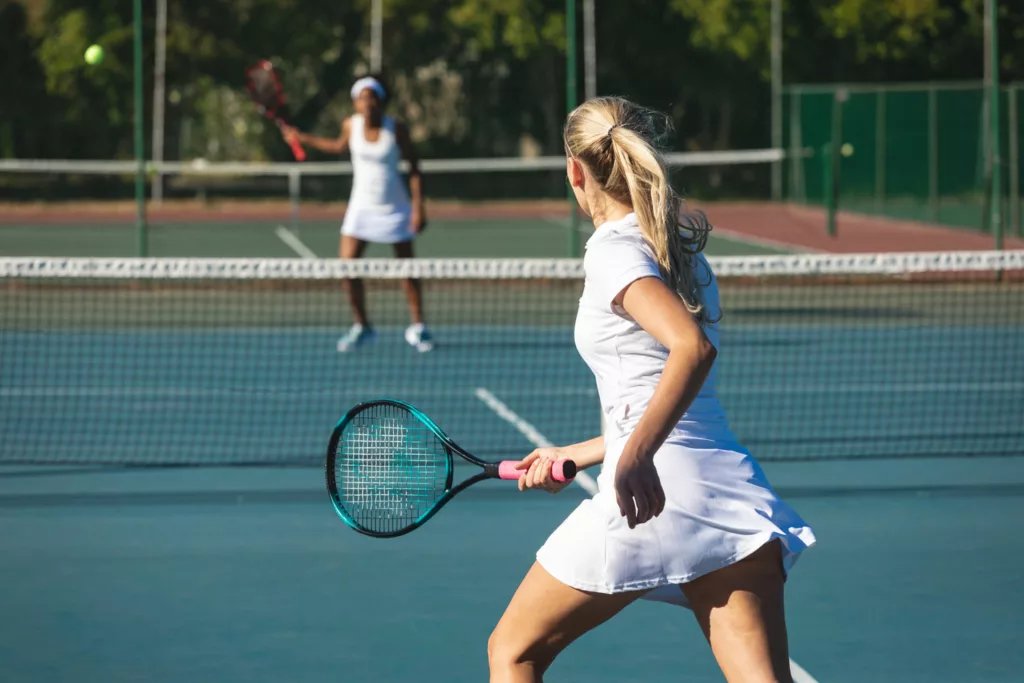 due donne giocano a tennis felici