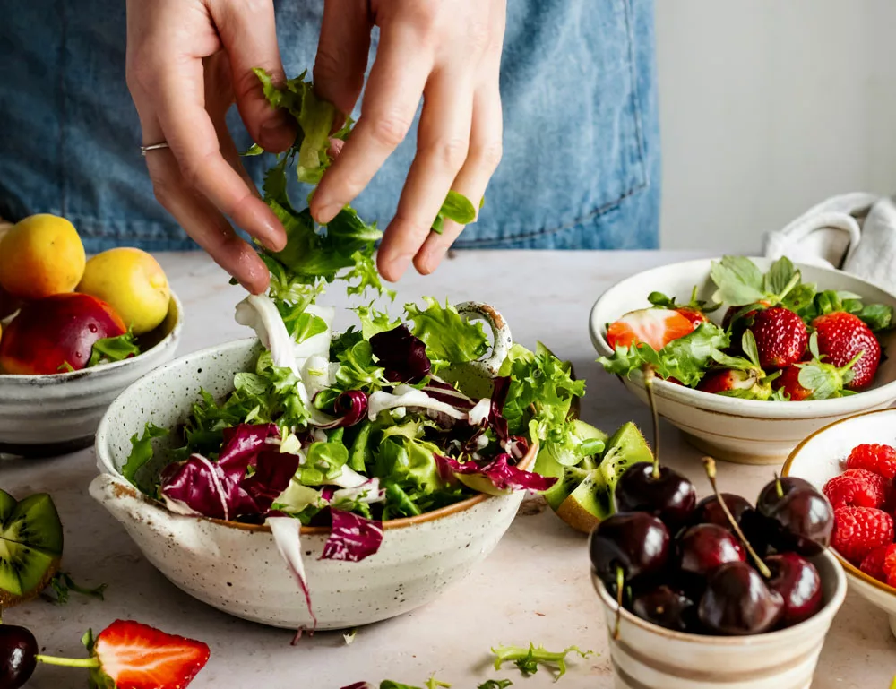 donna cucina frutta e verdura per avere un corretto stile alimentare