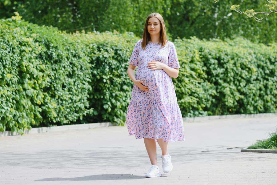 donna in gravidanza fa esercizio fisico e cammina al parco 