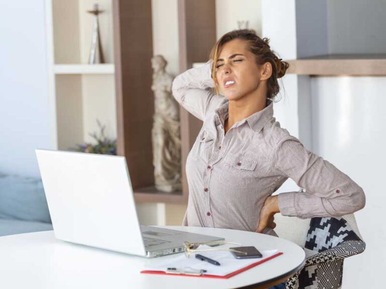 donna con espressione dolorante perché ha mal di schiena