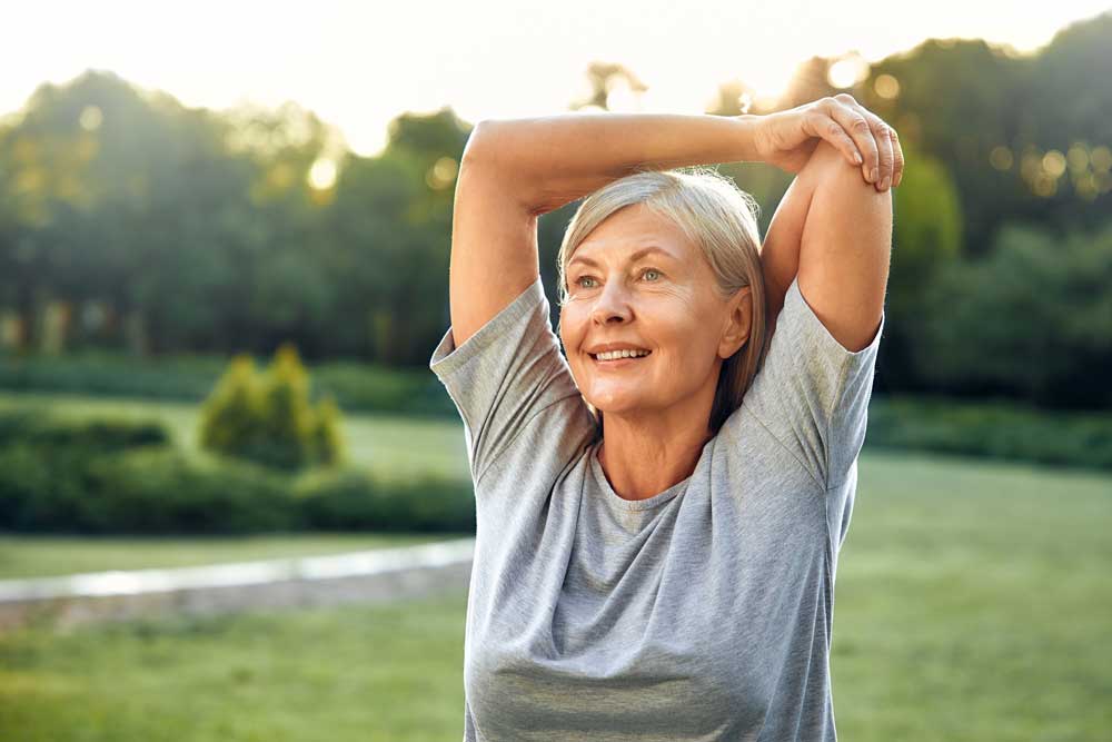 donna fa Esercizi di ginnastica posturale al parco ed è felice