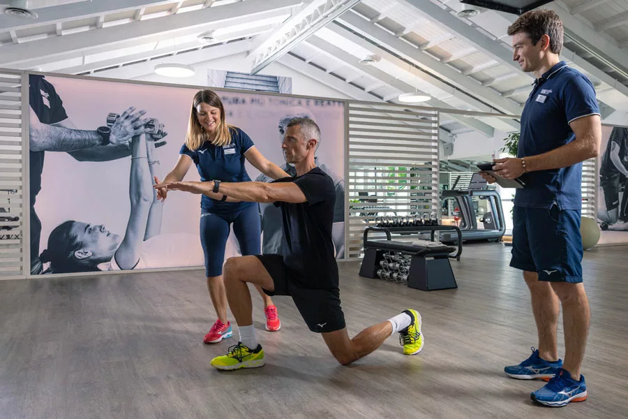 uomo si allena per dimagrire con un personal trainer in palestra