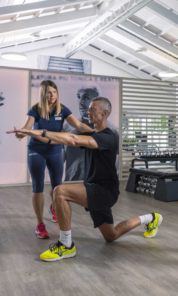 uomo si allena in palestra con personal trainer e fa rieducazione propriocettiva
