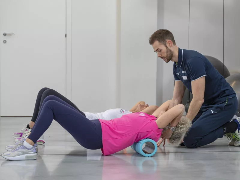donna si allena con il supporto di un personal trainer che la allena in modo personalizzato