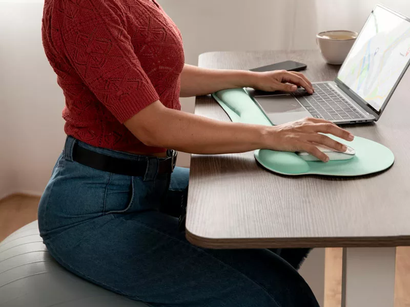 donna seduta in ufficio con una postura corretta