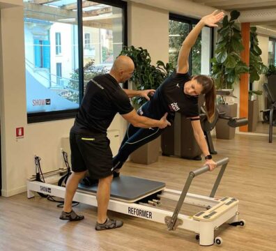 Donna sorridente fa insieme a personal trainer a Padova Reformer pilates