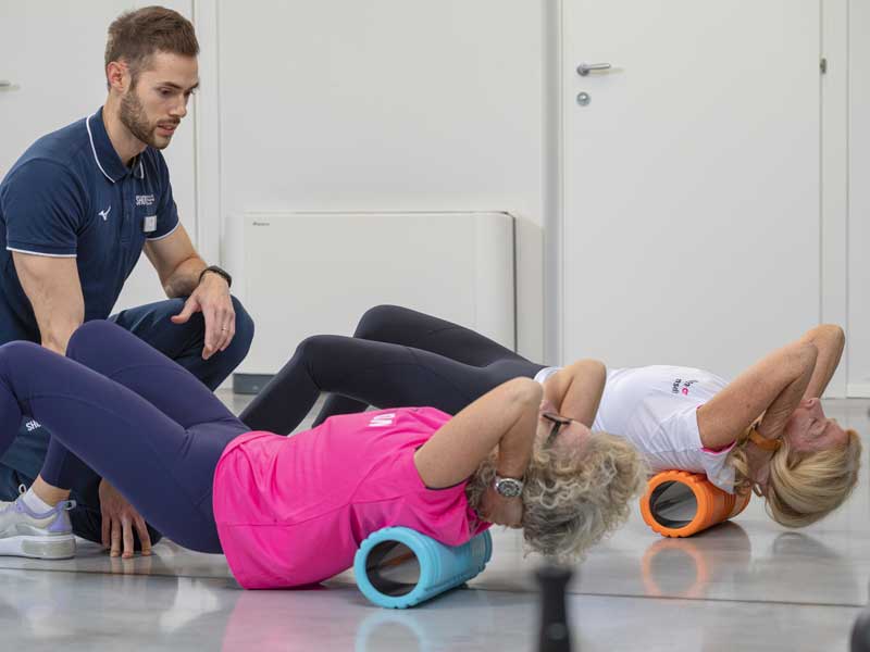 allenamento di gruppo con esercizi per la schiena con l'utilizzo del foam roller