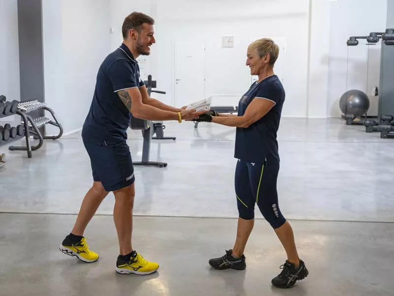 personal trainer accoglie una donna sorridente pronta ad allenarsi a Padova