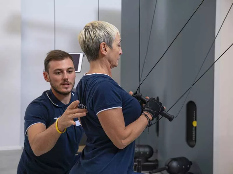 donna fa un allenamento cucito su misura insieme al suo personal trainer e allena i muscoli della schiena