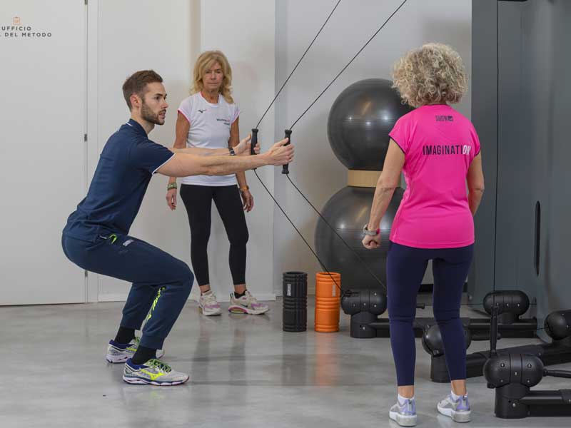personal trainer fa vedere l'esecuzione dell'esercizio ad un group training