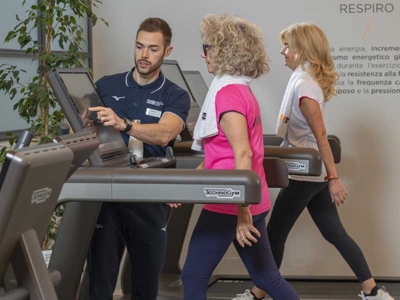 personal trainer guida un group training e imposta la velocità dei Tapis Roulant