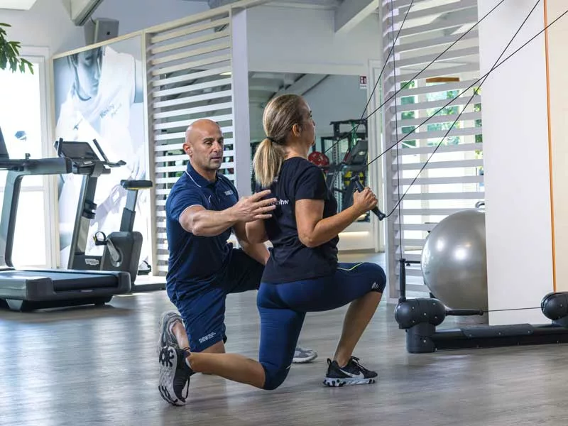 donna in affondo si allena in palestra con il kinesis. è seguita da un personal trainer nella sua palestra a Treviso