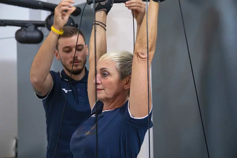 donna si allena in palestra a Padova seguita dal suo personal trainer e fa un allenamento personalizzato su misura secondo le sue esigenze 