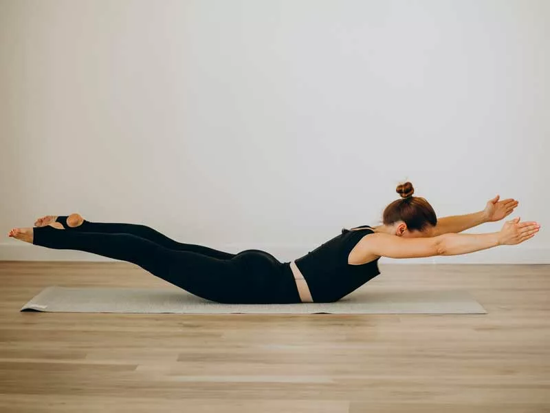 donna fa esercizi di pilates in palestar sopra un tappettino 