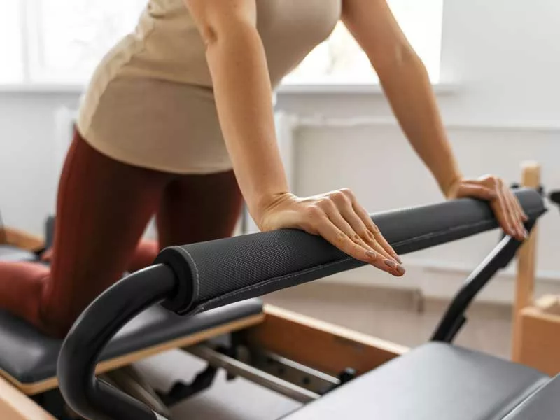 donna fa pilates in palestra con il reformer