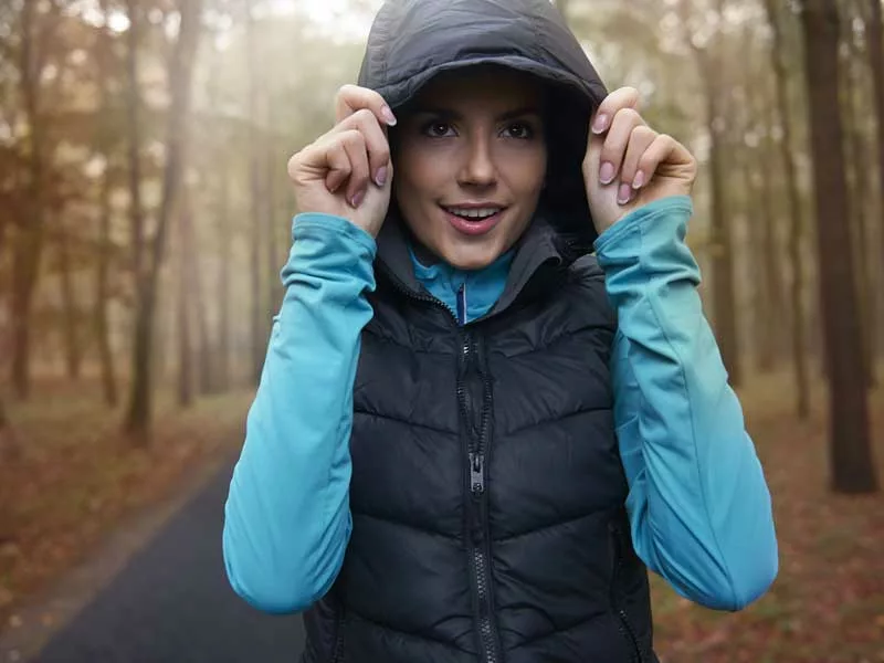 donna si veste a strati per andare a correre all'aria aperta in inverno