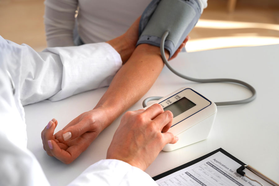 medico misura la pressione al paziente per controllare se ha la pressione alta