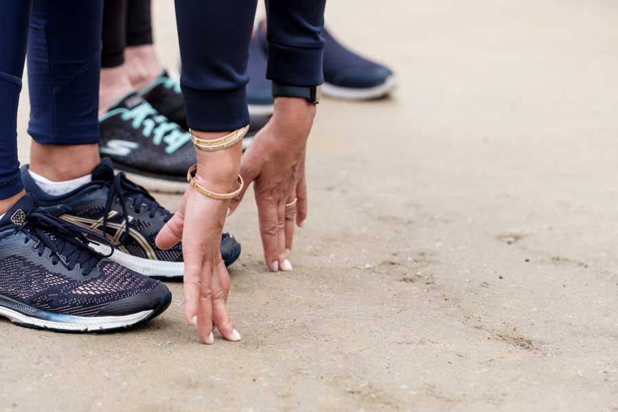 Un gruppo di donne esegue esercizi di stretching prima dell’allenamento di gruppo.
