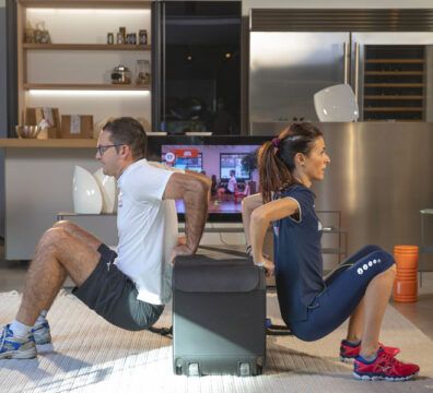 Uomo e donna si allenano insieme a casa in un allenamento di gruppo, eseguendo esercizi per rinforzare le braccia