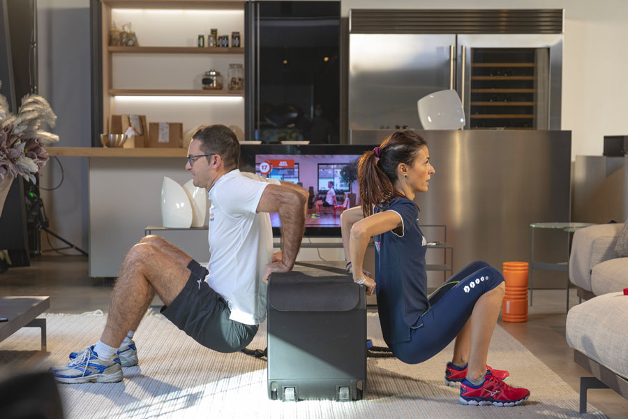 Uomo e donna si allenano insieme a casa in un allenamento di gruppo, eseguendo esercizi per rinforzare le braccia