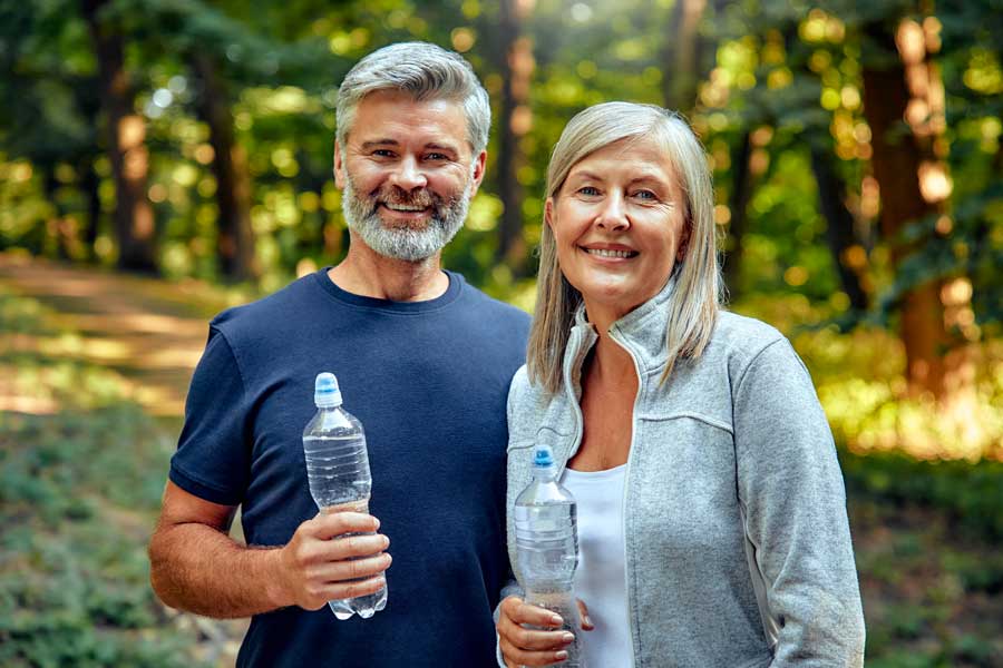 Uomo e donna sorridenti dopo l’allenamento, riflettono energia e benessere.