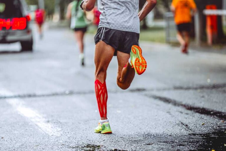 gambe di un uomo che corre sull'asfalto