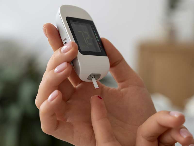 Puntura sul dito con dispositivo per misurare il livello di glicemia nel sangue."