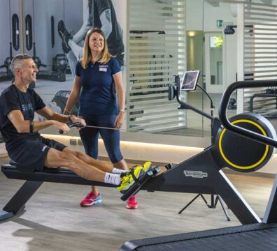 uomo in palestra sul reamatore si allena seguito da un personal trainer esperta