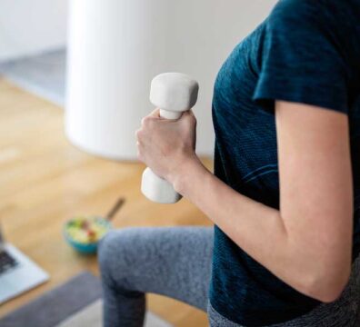 allenamento i ufficio durante la pausa pranzo. donna si allena con pesi in mano