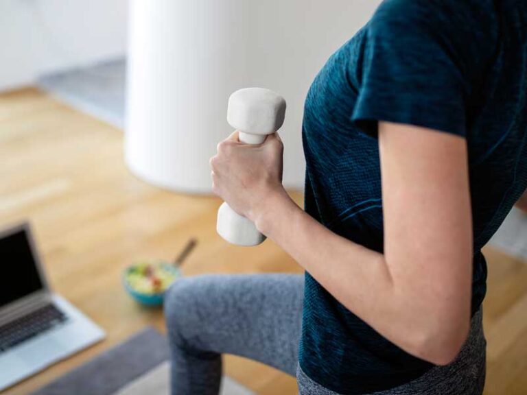 allenamento i ufficio durante la pausa pranzo. donna si allena con pesi in mano