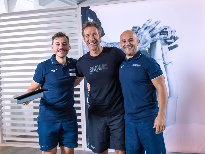 cliente sorride insieme ai suoi personal trainer dopo un allenamento a show club