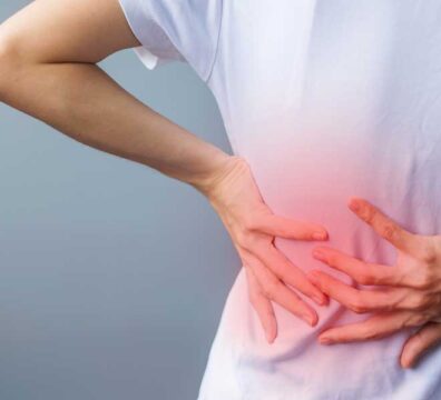 Le mani sostengono la schiena a causa del dolore.